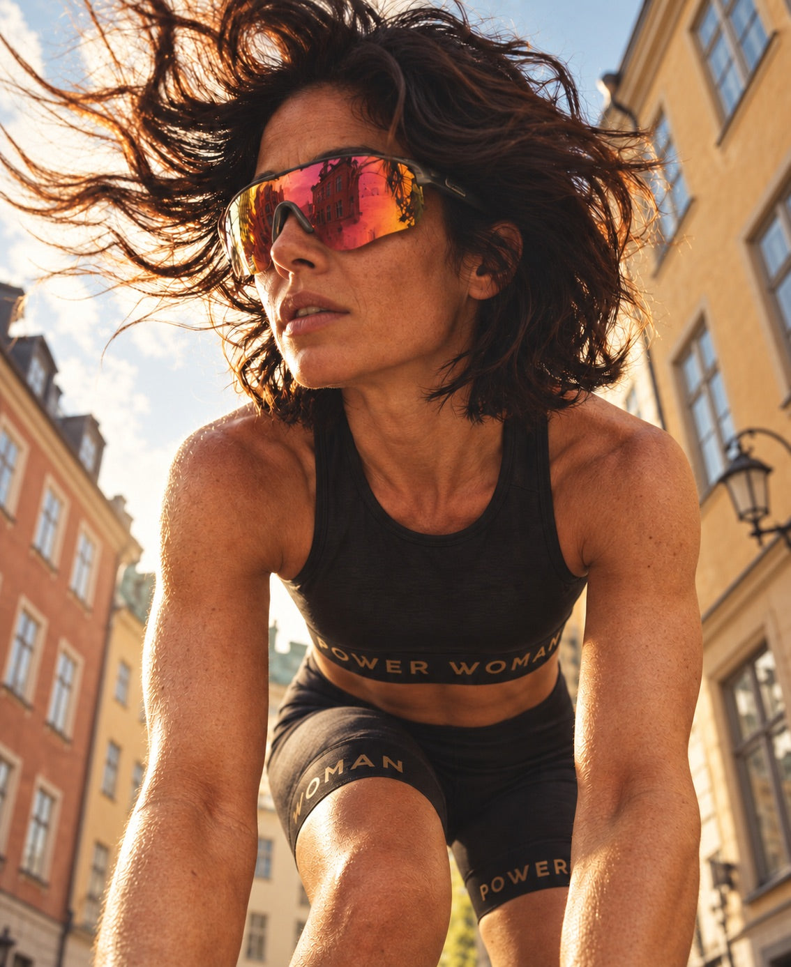 Woman in Power Woman training clothes and sports sunglasses, outdoors in the city.