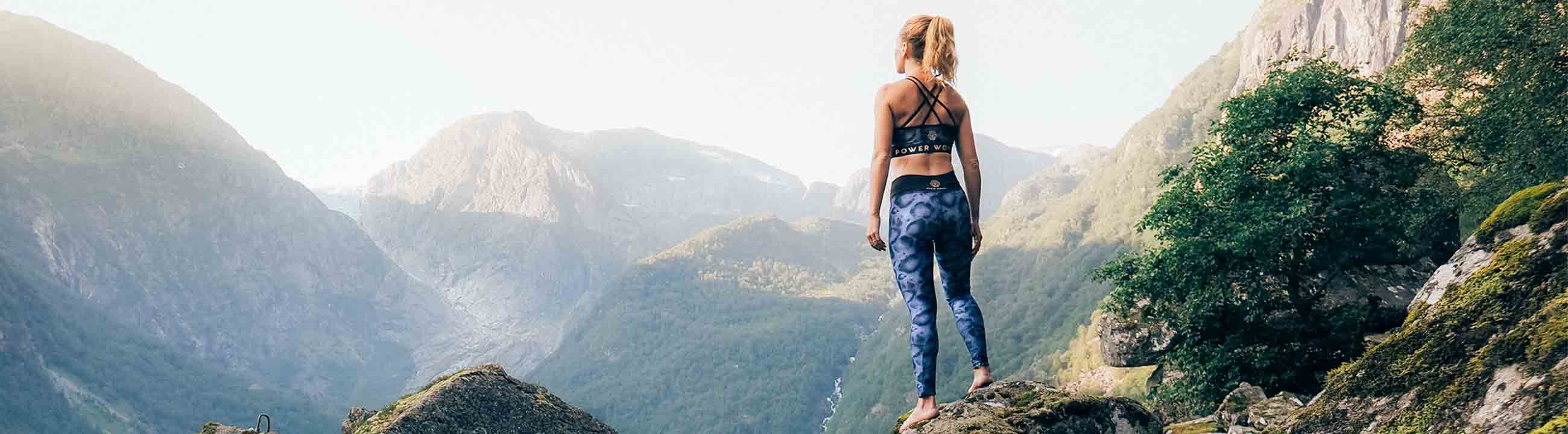 View of a Power Woman in leopard print sports leggings, overlooking the mountains in Norway